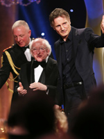 Liam Neeson on stage to accept his award from President Michael D. Higgins	
