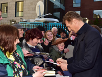 	IFTA Outstanding Contribution to Cinema recipient Liam Neeson signing autographs for fans on the red carpet	
